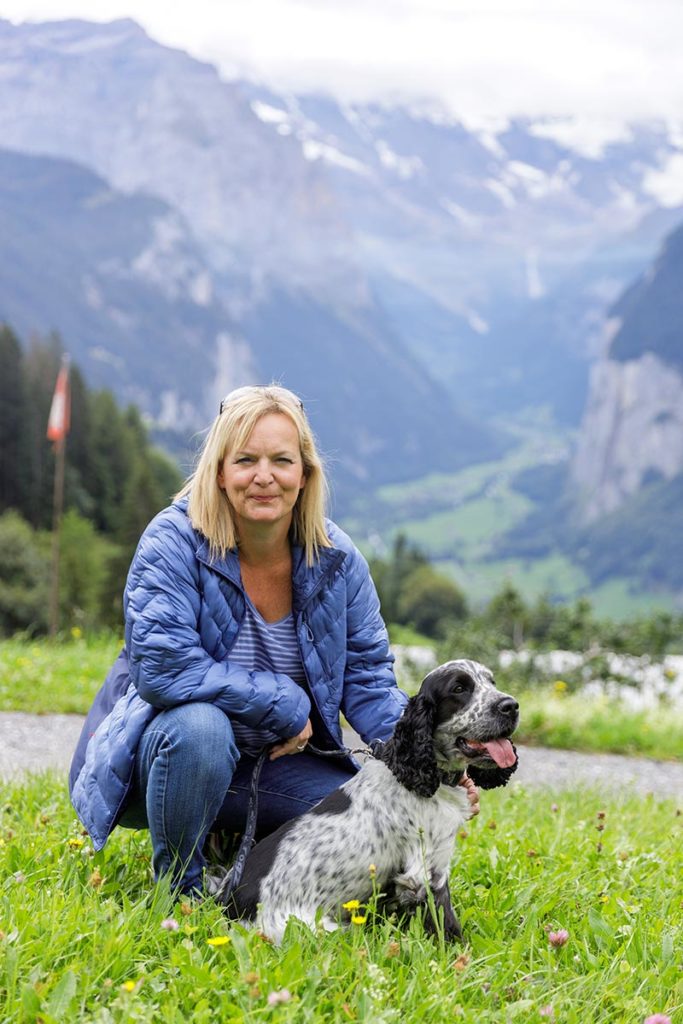 Picture of Emma Wilson, Swiss wedding videographer, posing with her dog with the Swiss Alps in the background.