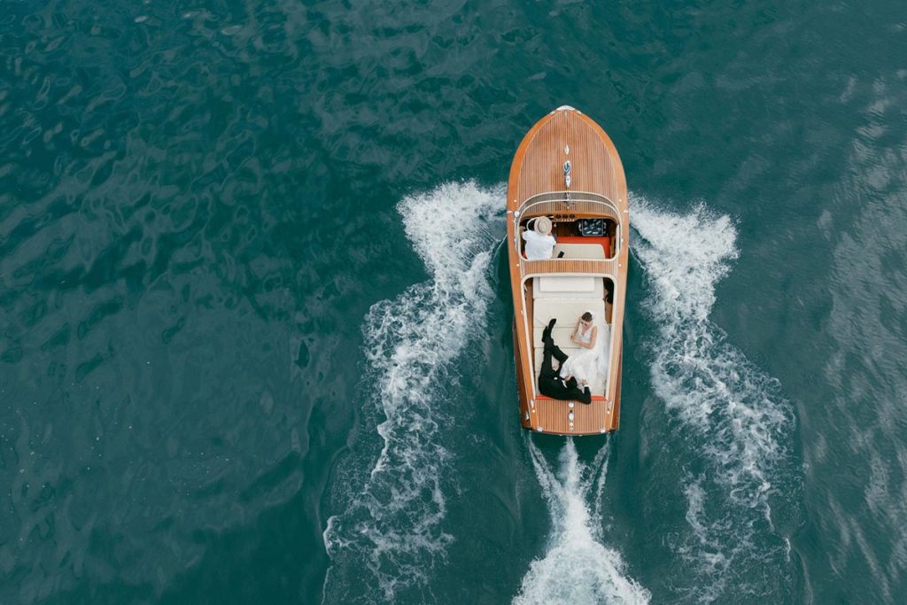 Bride and groom enjoying a romantic boat ride on Lake Geneva during their Swiss destination wedding.