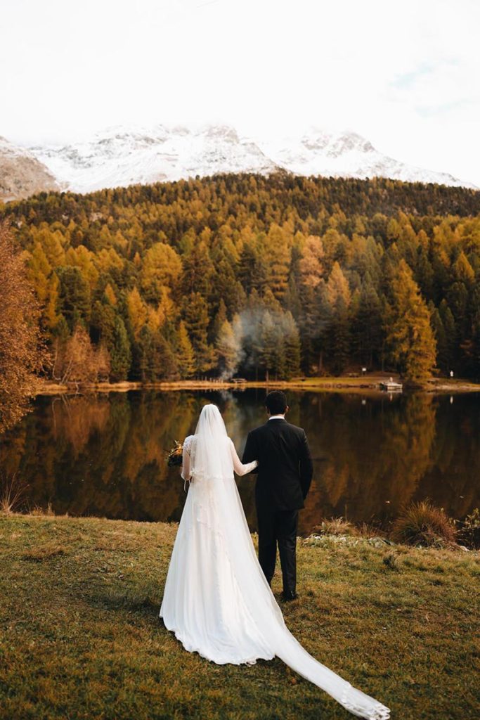 Newly married husband and wife look out over the larch trees after their wedding at Suvretta House in St. Moritz.