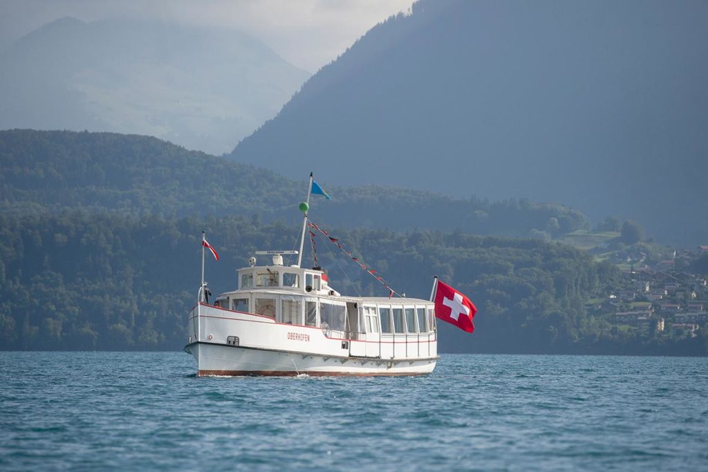 Boat on Lake Thun in Switzerland with Swiss flag showing.