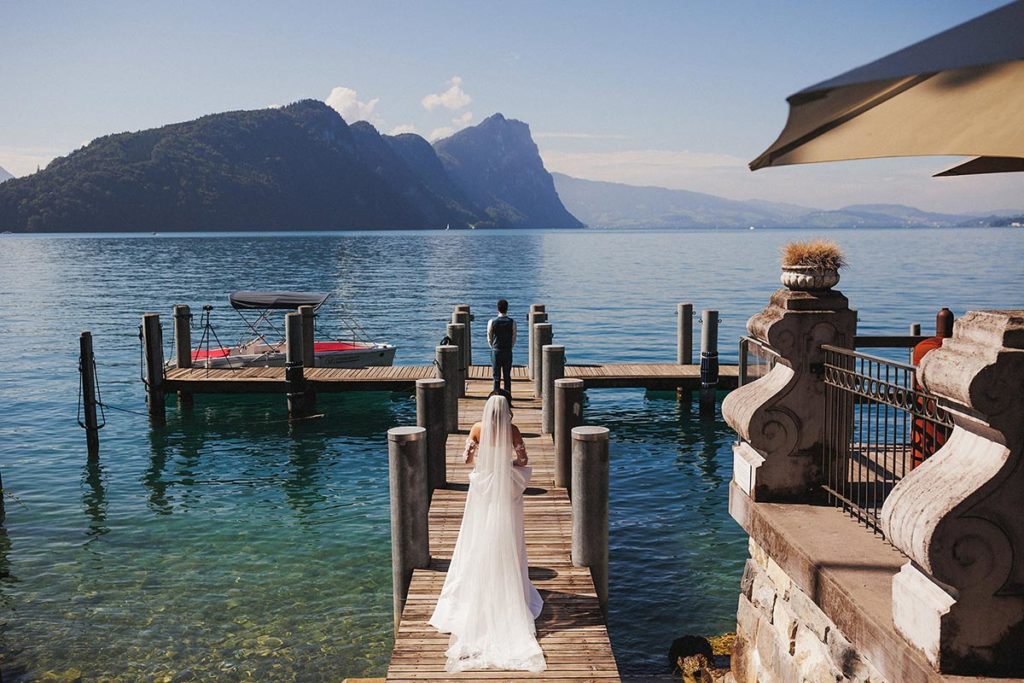 First look photo on a dock on Lake Lucerne, from a small wedding ceremony at Hotel Vitznauerhof.