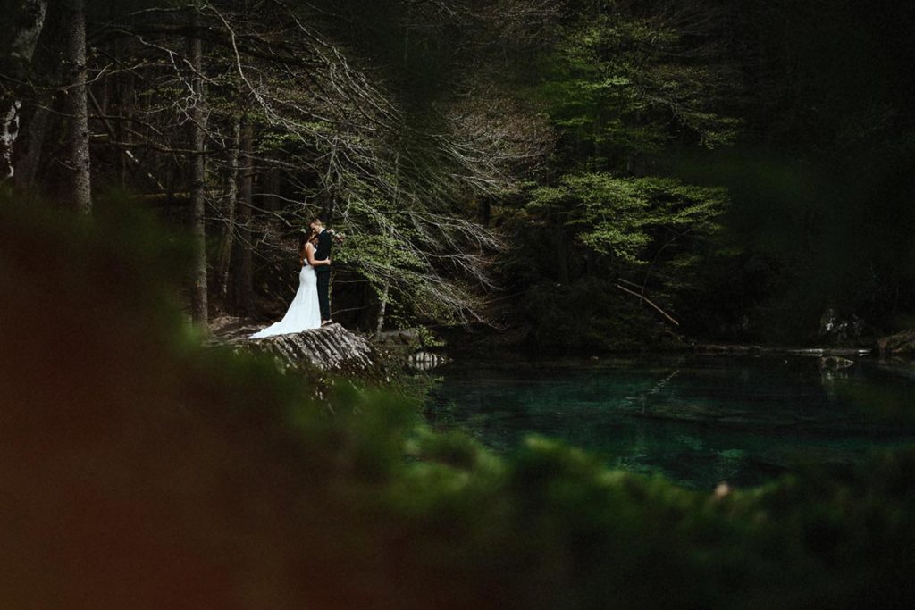 Wedding photo of a man and woman on the shores of Lake Blausee in Switzerland.