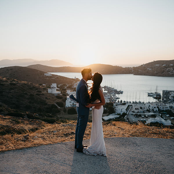 A bride and groom kiss at sunset after their wedding on Ios, Greece