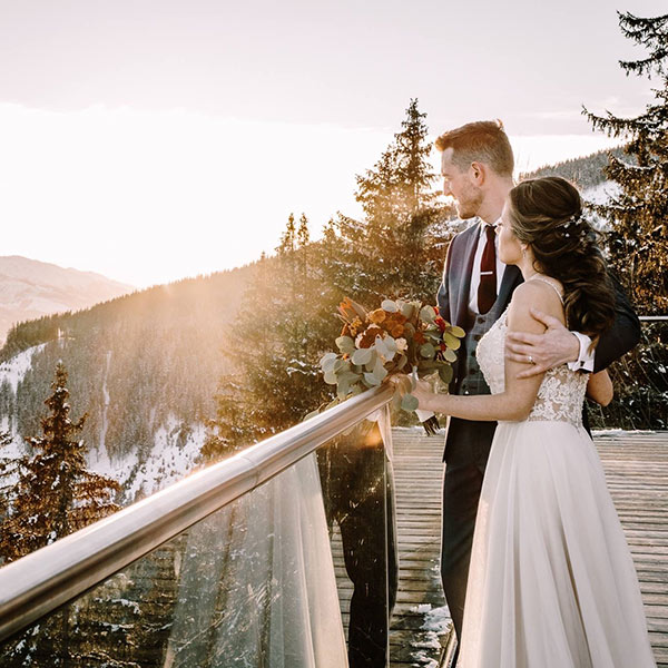 A bride and groom stand on a balcony on their wedding day at The Areit Lounge, Zell Am Zee, Austria