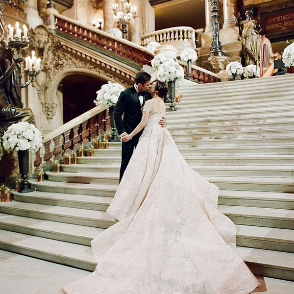 A bride and groom embrace on the steps of the Opera Garnier in Paris on their wedding day