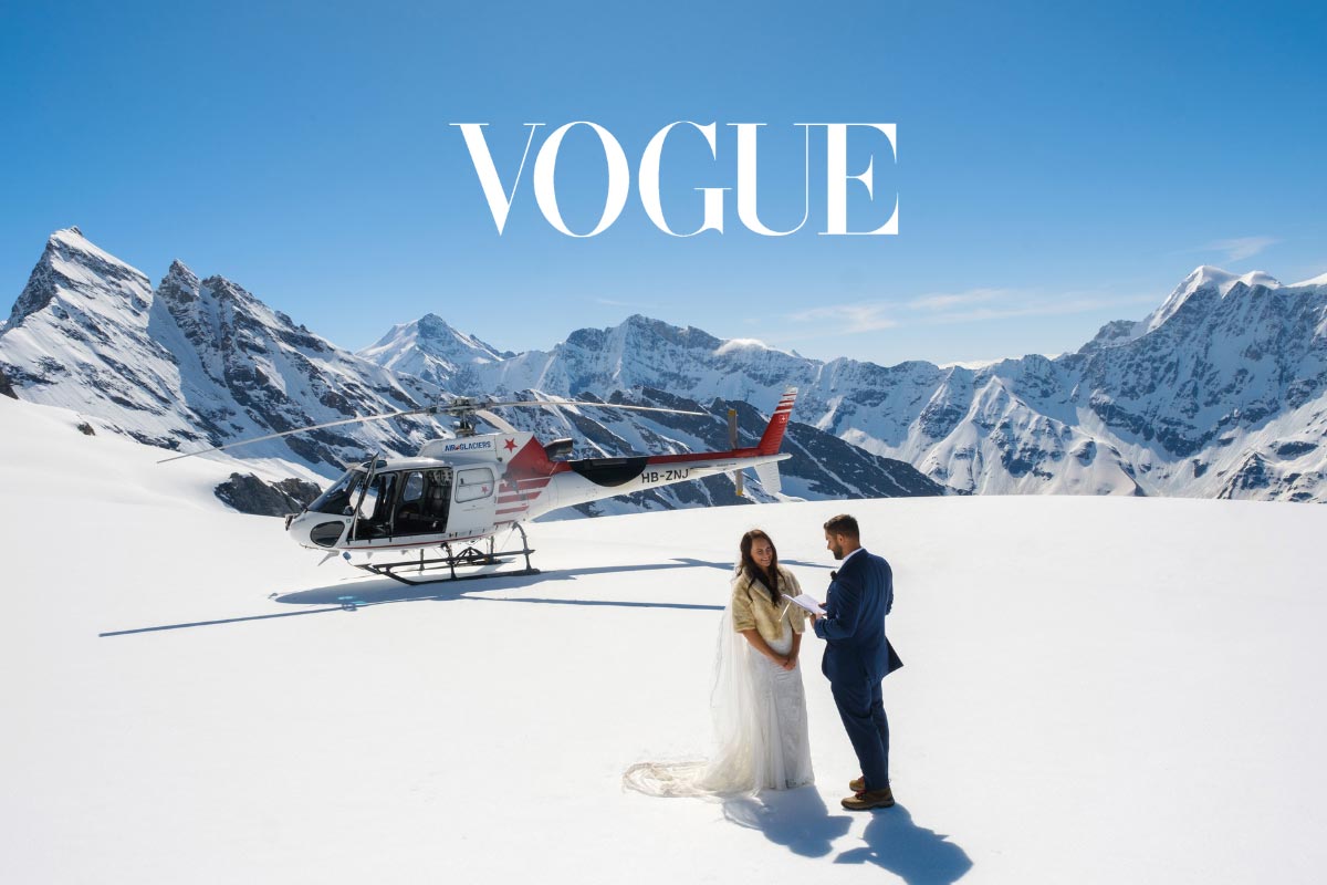 A wedding couple exchange vows on top of a glacier in Switzerland, with a helicopter in the background.