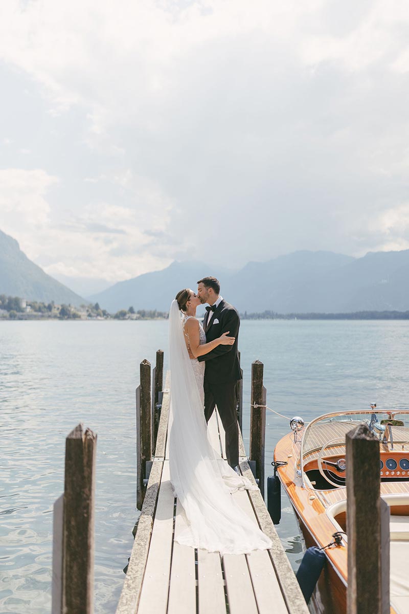 Un couple s'embrasse sur une jetée du lac Léman lors de leur mariage au Montreux Palace en Suisse.